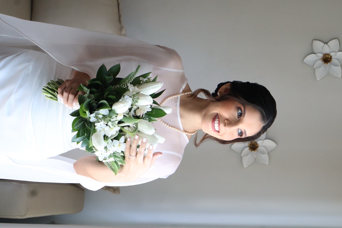 Novia con ramo de lirios y maquillaje de piel blindada