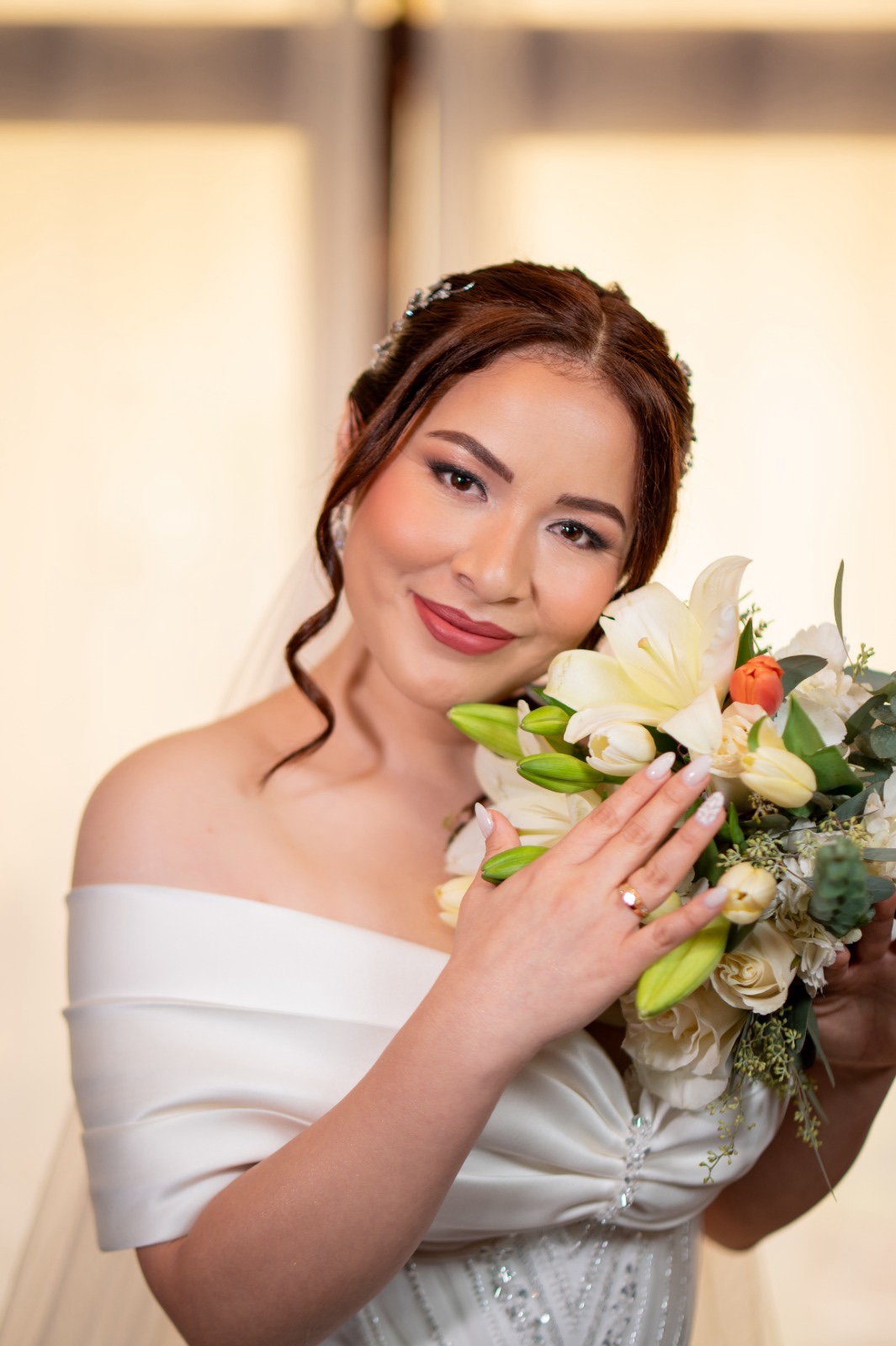 Novia con maquillaje natural elegante y ramo de lirios